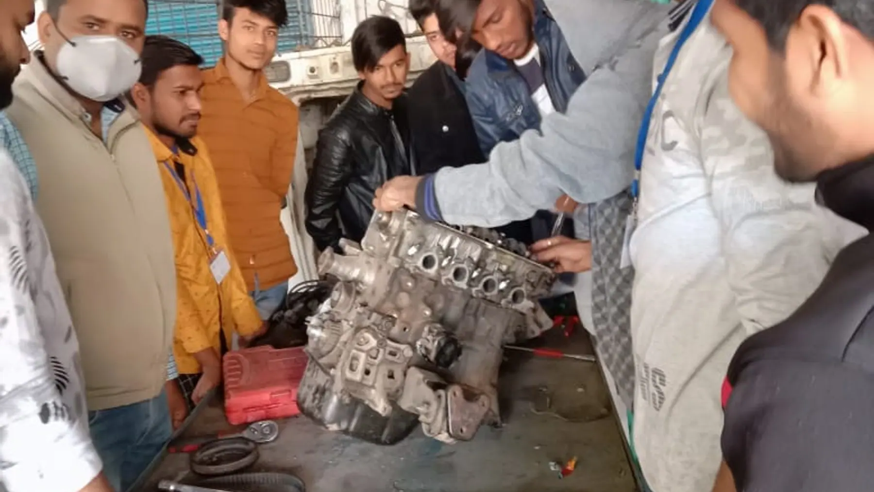 Trainees working hands-on with a live engine on a training bench